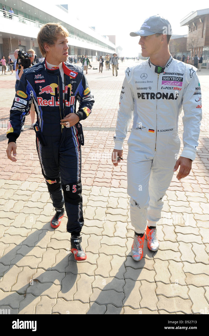 German drivers Michael Schumacher of Mercedes GP (R) and Sebastian Vettel  of Red Bull Racing (L) walk through the paddock at Korea International  Circuit in Yeongam, South Korea, 22 October 2010. The
