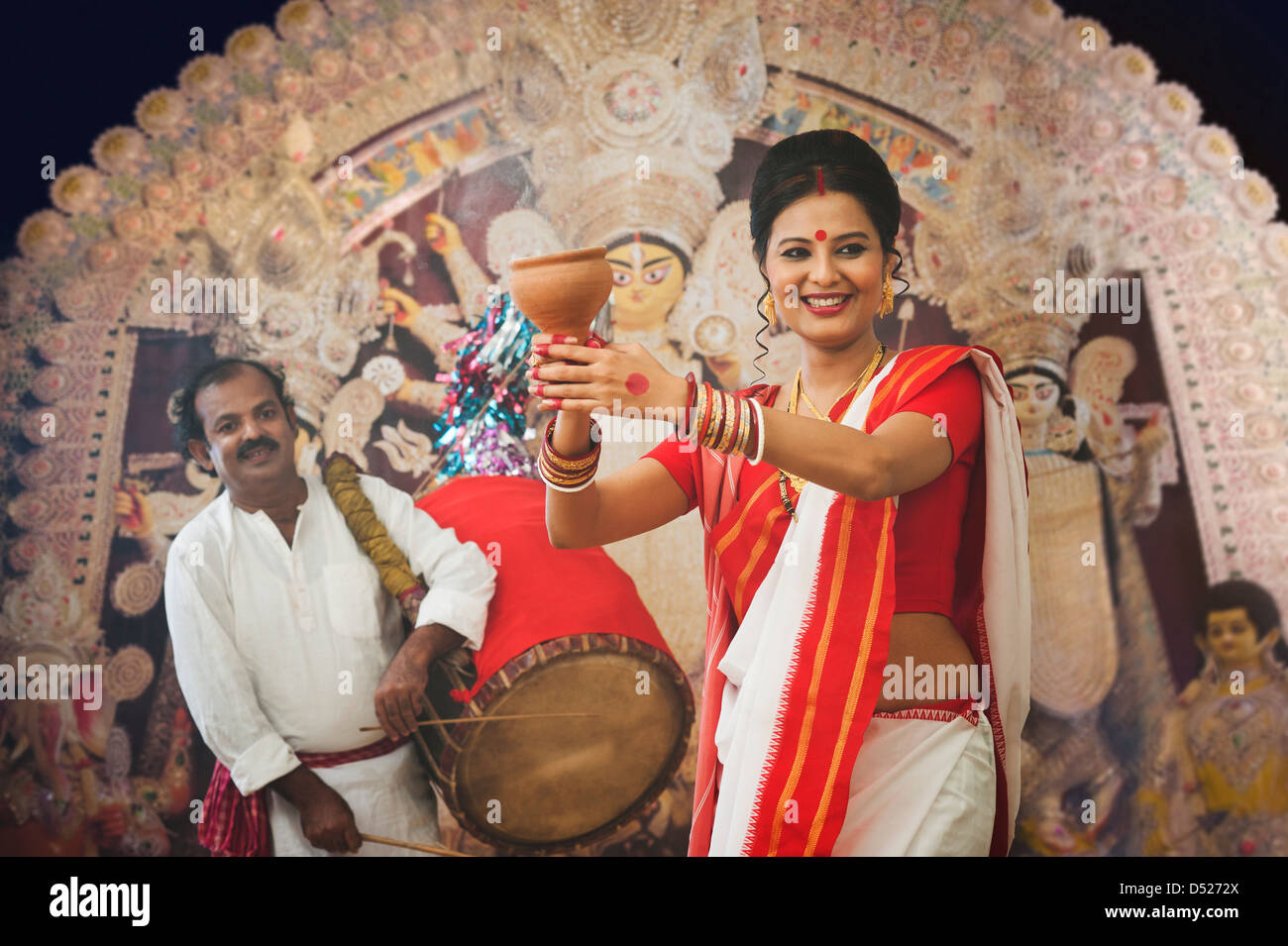 Bengali woman performing Dhunachi Dance and a Dhaki playing Dhak at