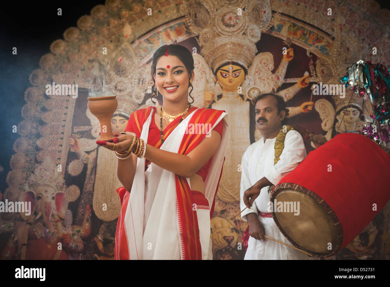 Bengali woman performing Dhunachi Dance and a Dhaki playing Dhak at
