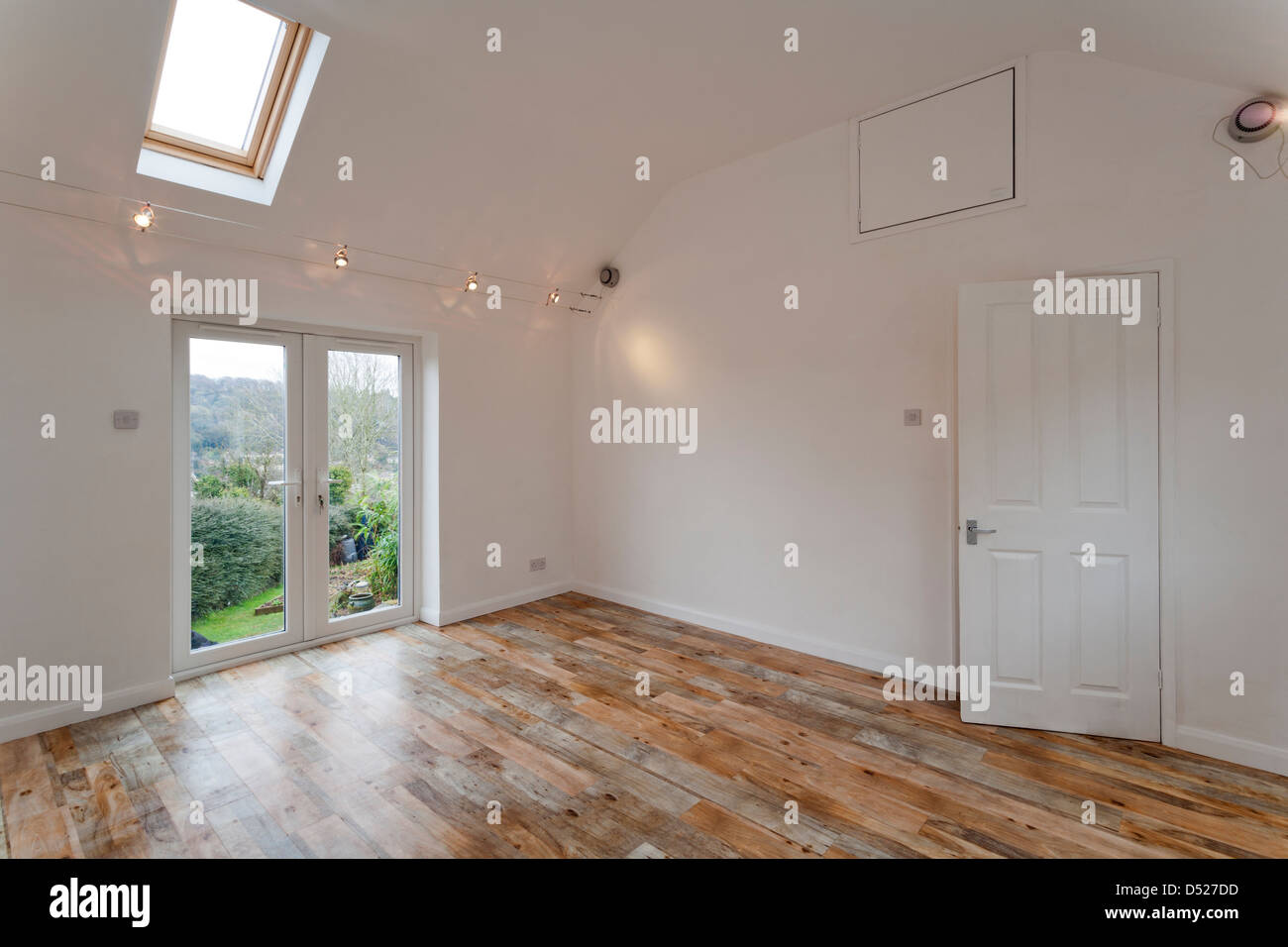 A large new unoccupied white painted high ceilinged empty room with Velux skylights. Stock Photo