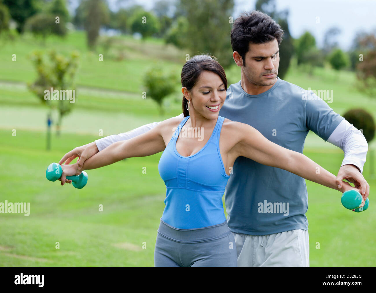 Hispanic man helping woman with hand weights Stock Photo Alamy