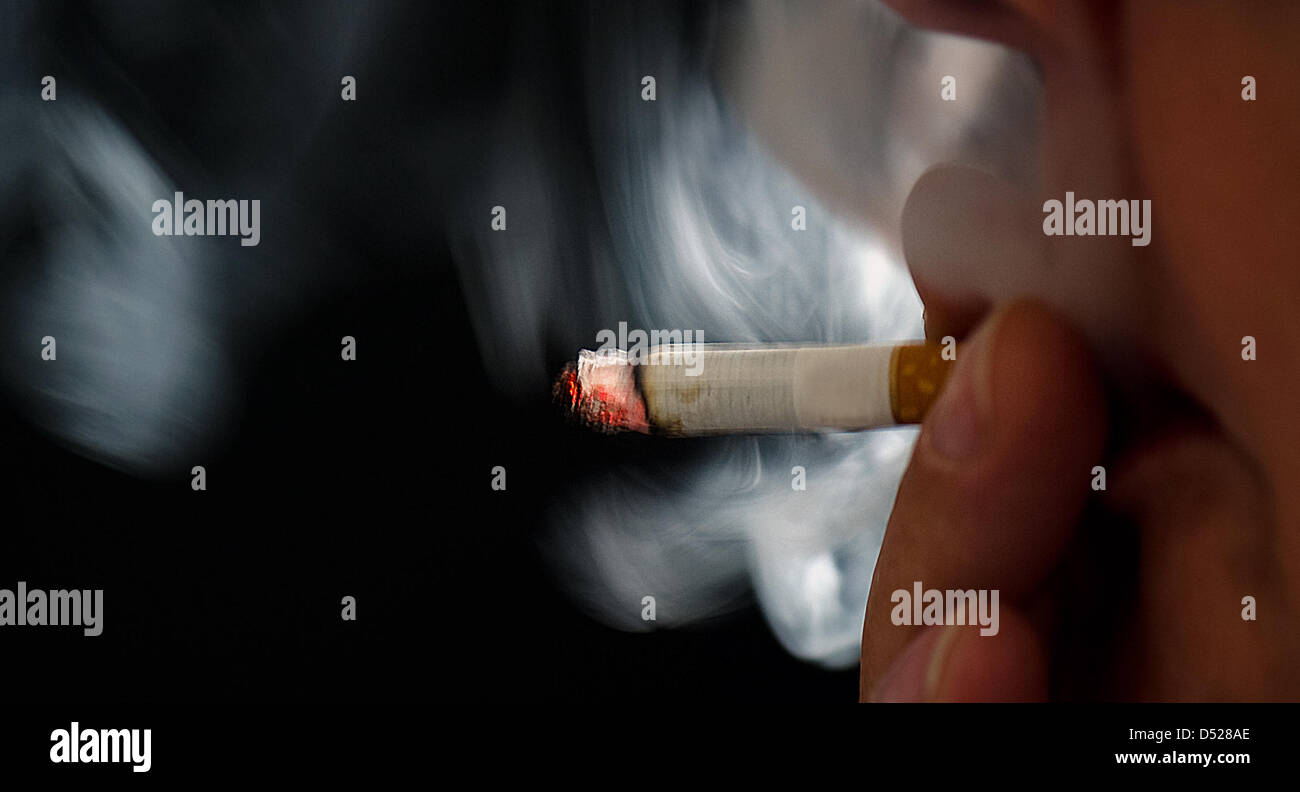 ILLUSTRATION - A smoker takes a drag from a cigarette in Dresden, Germany, 25 October 2010. Germany's governemnt plans to increase the tax on tobacco while alleviating the environmental tax burden on businesses. Photo: Arno Burgi Stock Photo