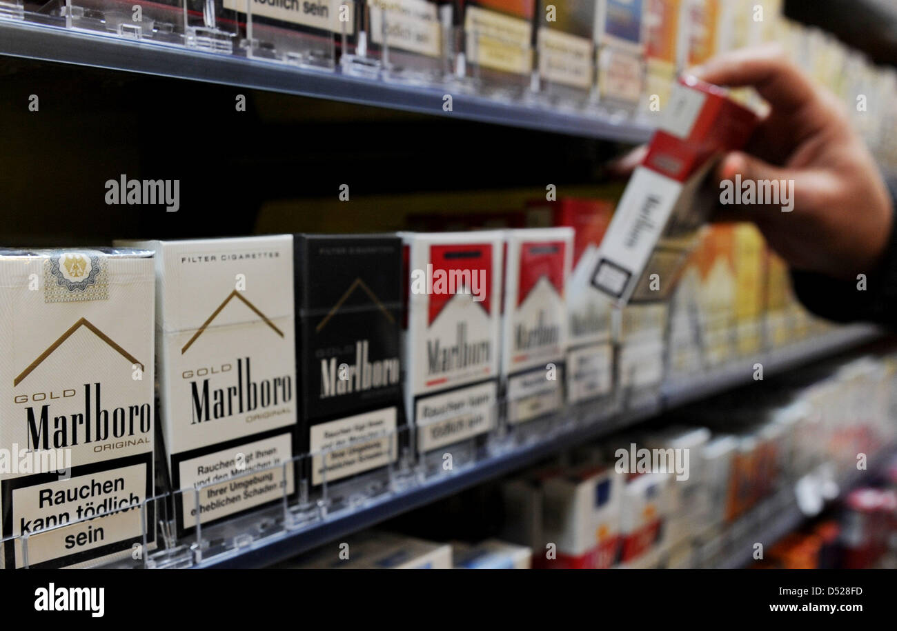 A vendor pulls a pack of cigarettes from a rack in a kisok in Hamburg, Germany, 25 October 2010. Germany's ruling coalition of conservative CDU and economy-friendly FDP aims to raise the tobacco tax in order to lower the so-called eco-tax, basically a tax imposed on environmental pollution, for energy-intensive and thus highly pollutive industries. Photo: ANGELIKA WARMUTH Stock Photo