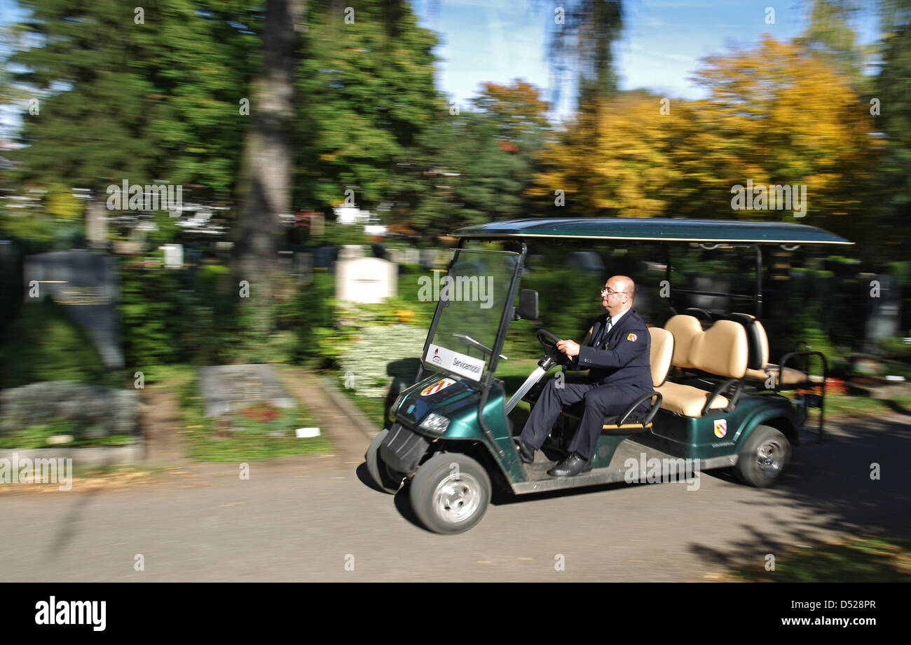 Ein Mitarbeiter des Westfriedhofs in Nürnberg (Mittelfranken) fährt auf einem Golfkart über das Friedhofsgelände (Foto vom 08.10.2010). Die Waldgrünen Golfkarts warten auf dem Westfriedhof in Nürnberg auf Besucher. Mit den Servicemobilen fahren Mitarbeiter der Friedhofsverwaltung ältere und gebrechliche Hinterbliebene zu den Gräbern, so der Leiter der Nürnberger Friedhofsverwaltung Stock Photo