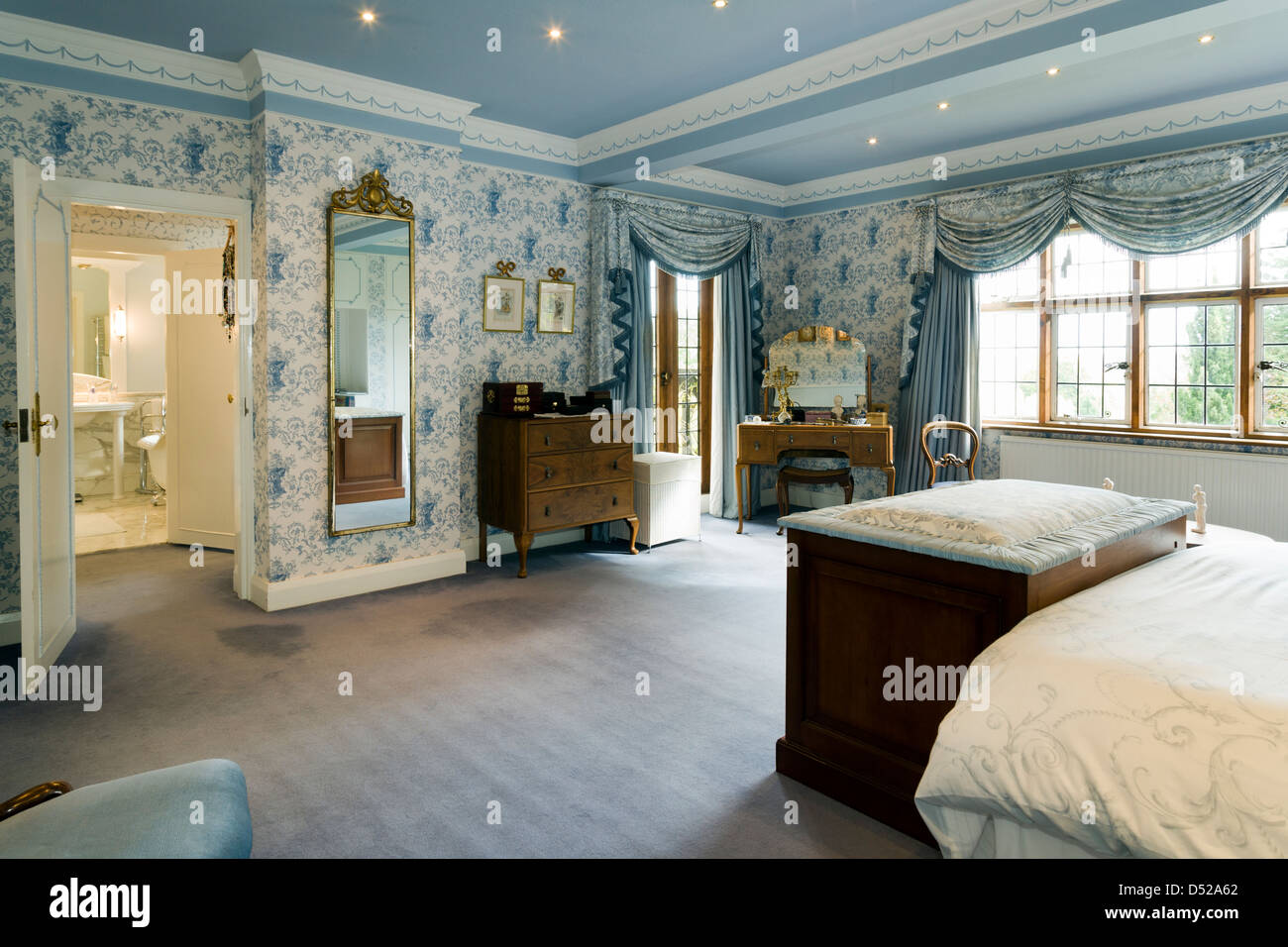 A large traditional bedroom with ensuite bathroom. Stock Photo