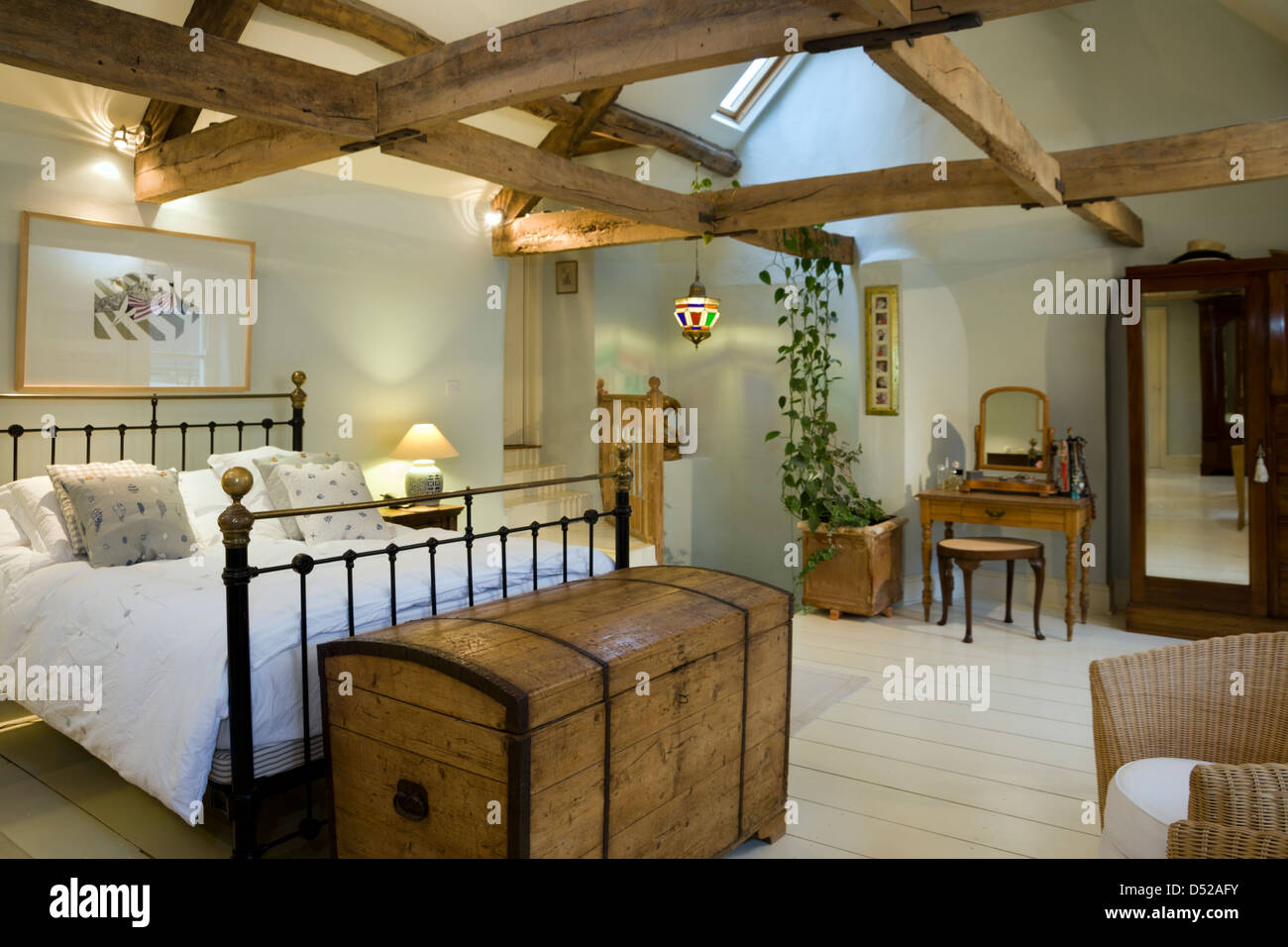 A large bedroom with an open ceiling and original period beam features. Stock Photo