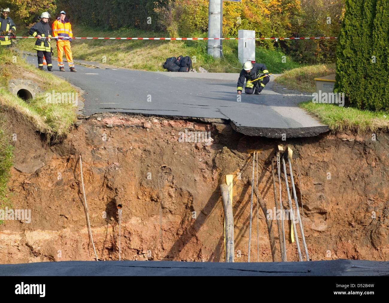 Firemen secure the perimeter of a sinkhole that has left a huge crater in the middle of a residential area in Schmalkalden, Germany, 01 November 2010. No one was hurt. The hole is about 20 metres deep. Photo: MICHEL REICHEL Stock Photo