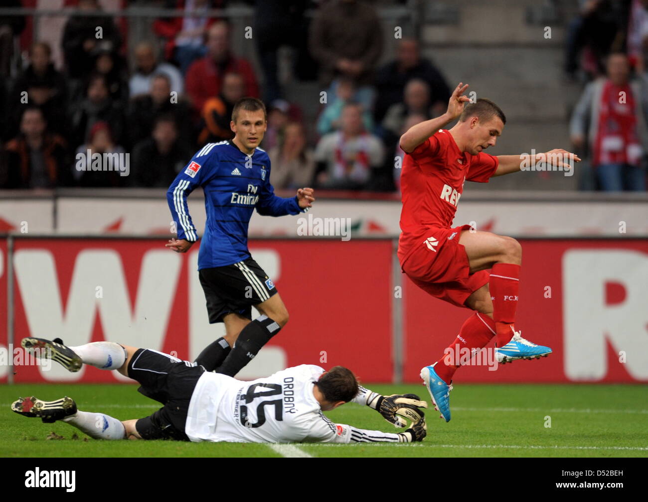 Cologne's Lucas Podolski (r) tackles Jaroslav Drobny and Robert Tesche from Hamburg during a German Bundesliga match at the RheinEnergie stadium in Cologne, Germany, 30 October 2010. Cologne won by 3-2. Photo: Federico Gambarini Stock Photo
