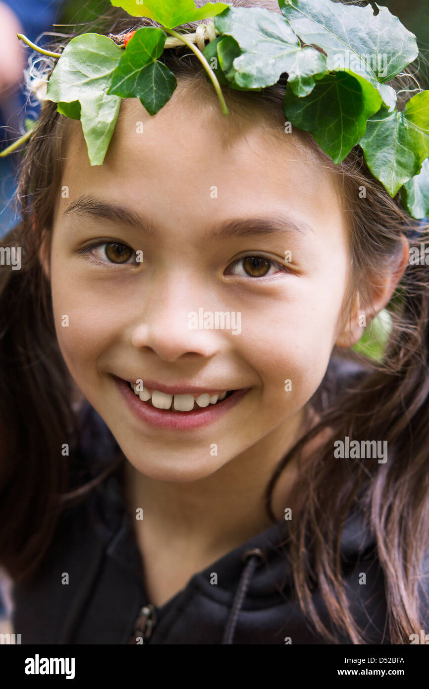 Mixed race girl wearing ivy wreath Stock Photo