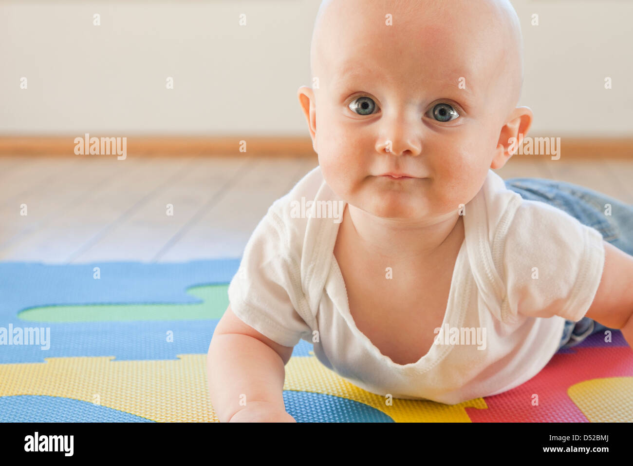 Caucasian baby crawling on plastic mat Stock Photo Alamy