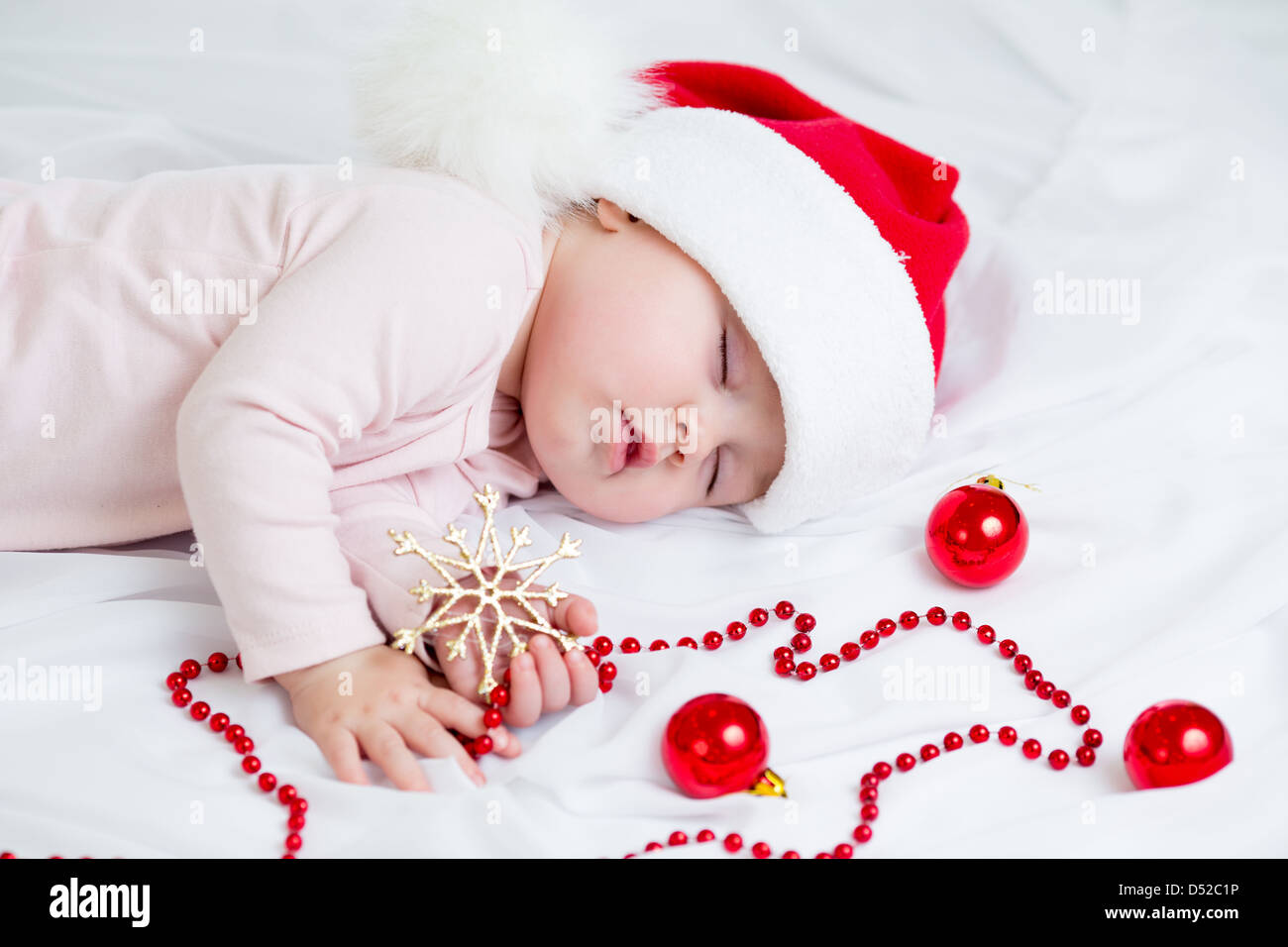 sleeping baby girl Santa Claus Stock Photo