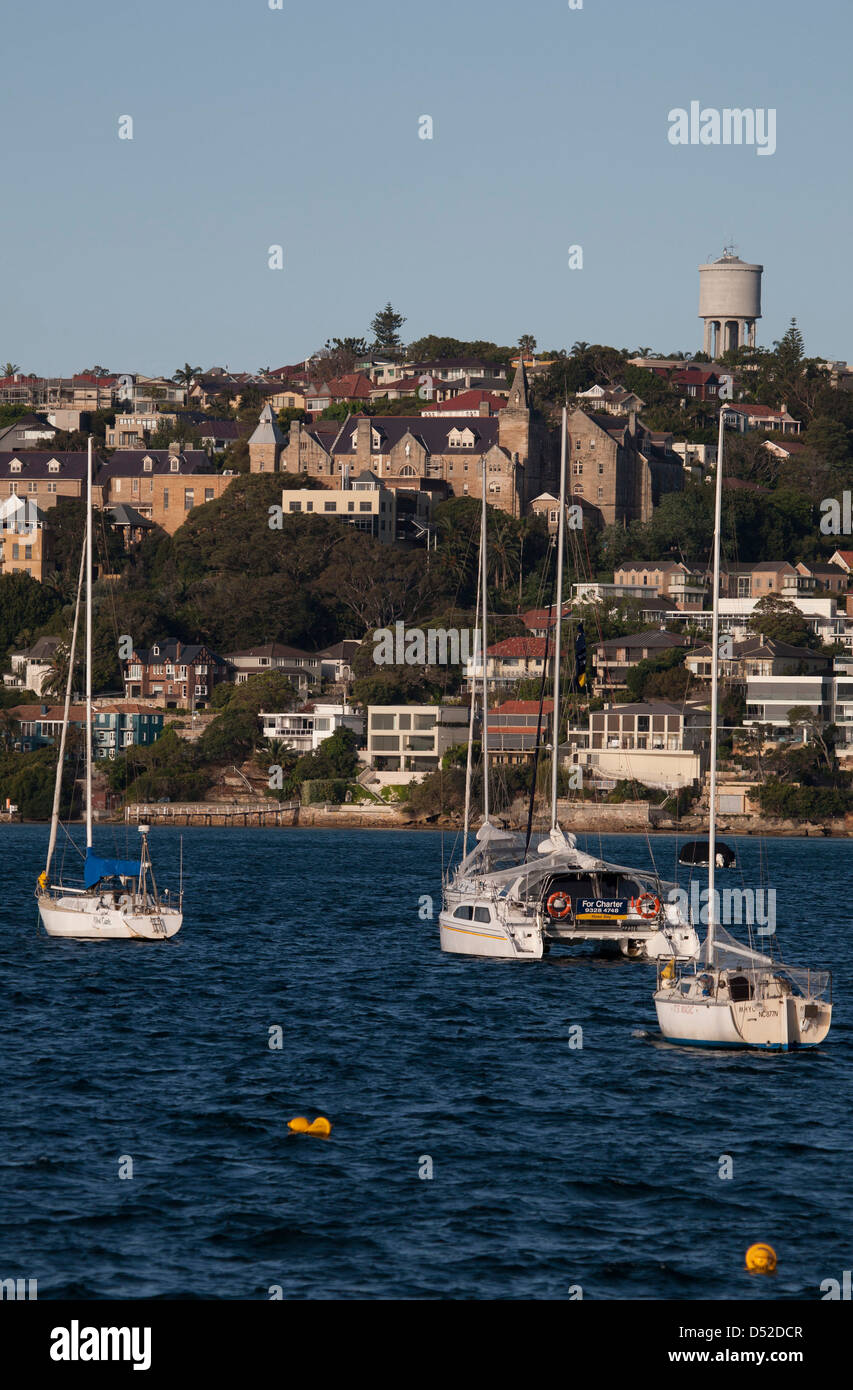 Luxury waterfront houses and moored pleasure boats in front of Kincoppal School at Rose Bay Eastern Suburbs Sydney Australia Stock Photo