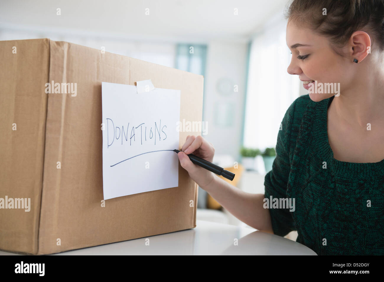 Hispanic girl marking ‚'donations' box Stock Photo