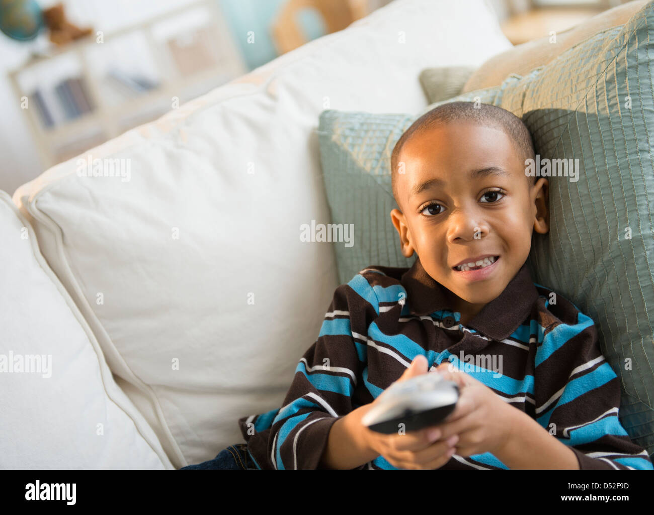 African American boy watching television on sofa Stock Photo