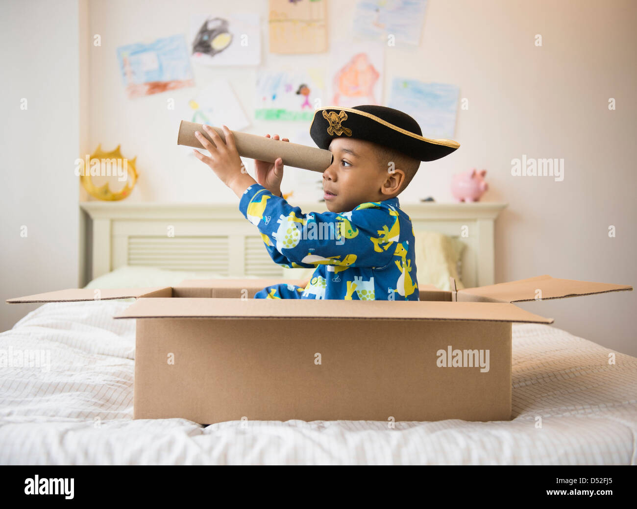 African American boy playing in cardboard box Stock Photo