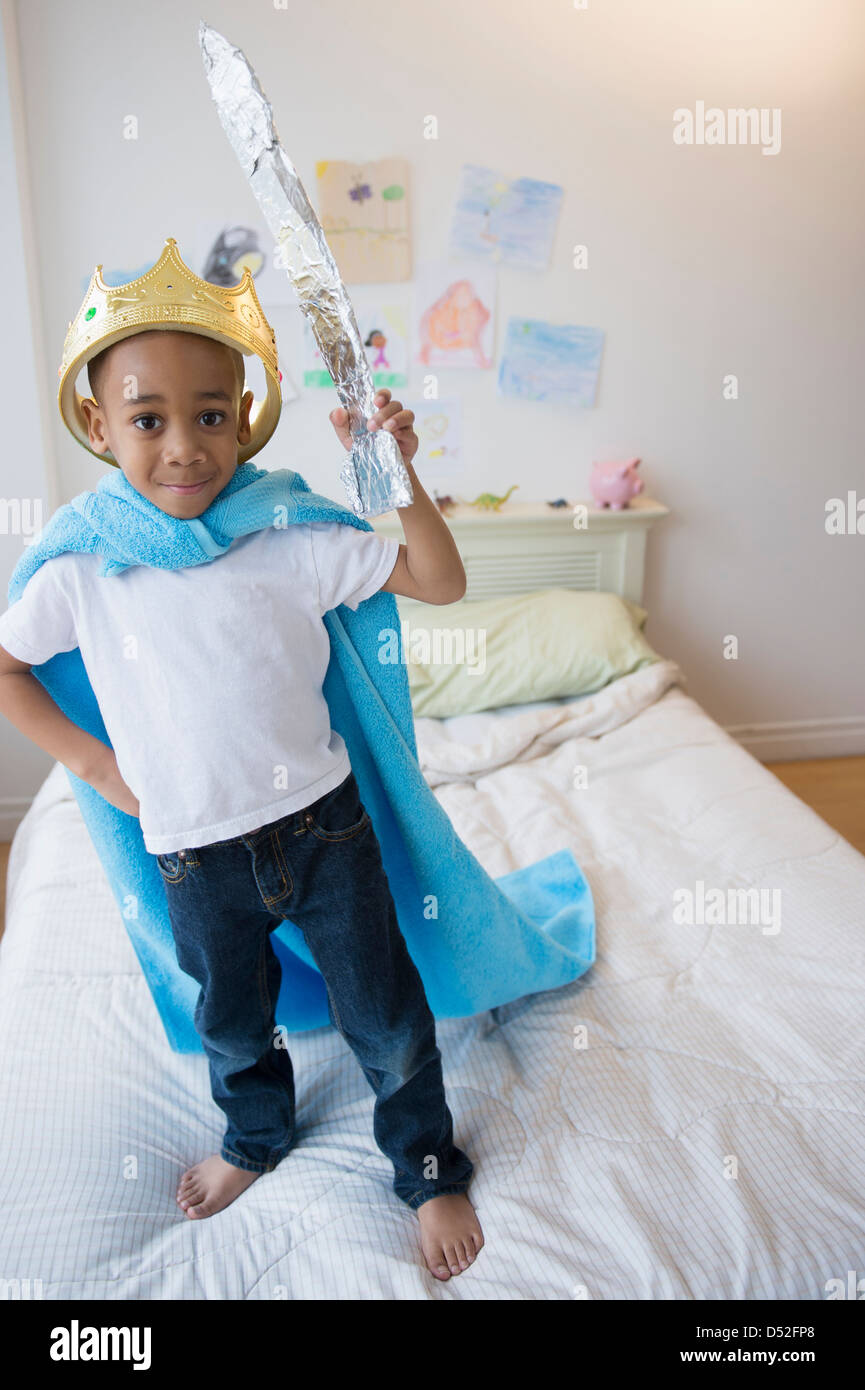 African American boy wearing costume on bed Stock Photo
