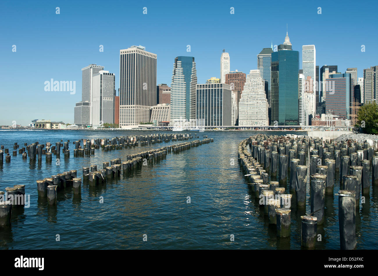 WOOD PILINGS PIER ONE BROOKLYN EAST RIVER TO MANHATTAN SKYLINE NEW YORK