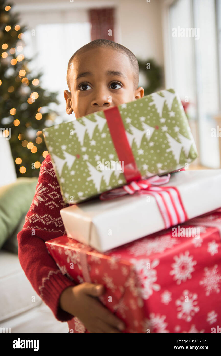 African American boy carrying Christmas presents Stock Photo