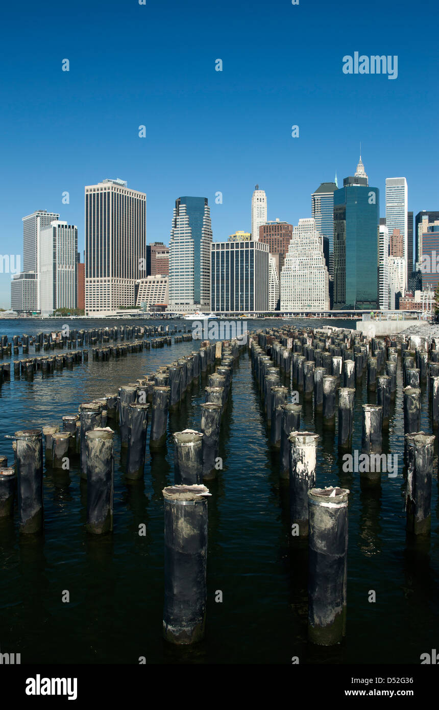 WOOD PILINGS PIER ONE BROOKLYN EAST RIVER TO MANHATTAN SKYLINE NEW YORK