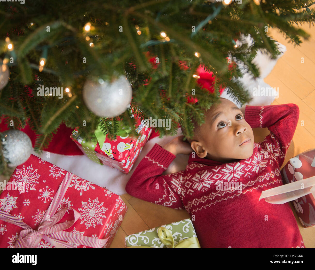 African American boy laying under Christmas tree Stock Photo Alamy