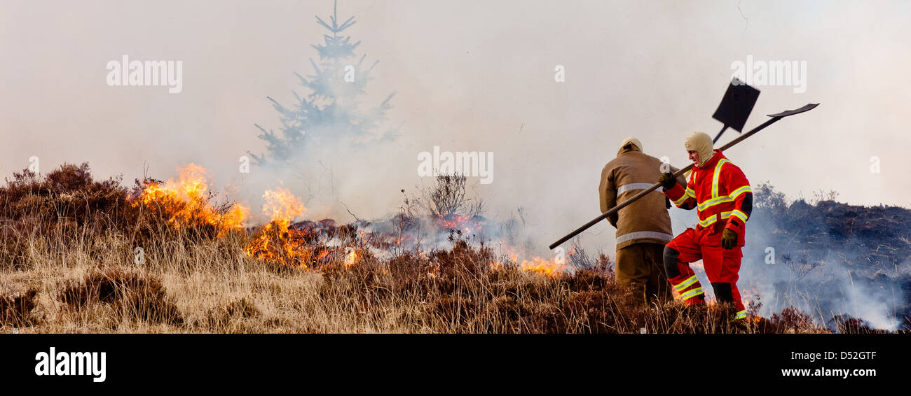 Firemen fight to control a moor hill fire on the west coast of Scotland Stock Photo