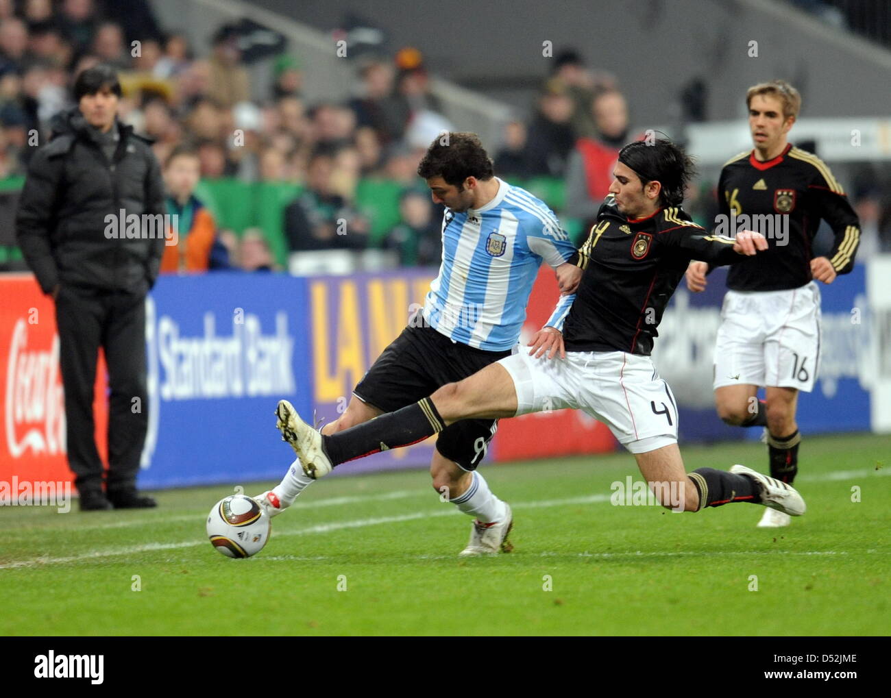 Germany's Serdar Tasci (C) and Argentina's Gonzalo Higuain vie for the ball during the soccer friendly match Germany vs Argentina at AllianzArena stadium in Munich, Germany, 03 March 2010. Photo: Bernd Weissbrod Stock Photo
