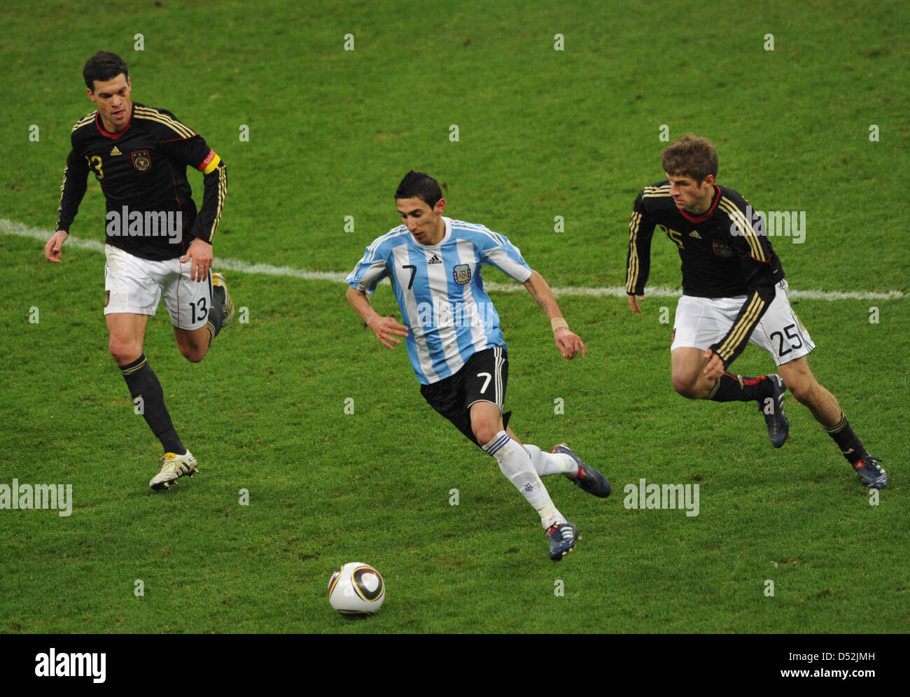 Germany's Michael Ballack (L) and Thomas Mueller (R) and Argentina's Angel di Maria vie for the ball during the soccer friendly match Germany vs Argentina at AllianzArena stadium in Munich, Germany, 03 March 2010. Photo: Peter Kneffel Stock Photo