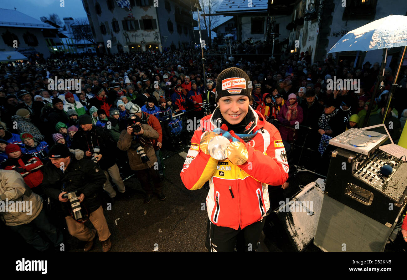 German biathlete Magdalena Neuner presents her medals on stage during the reception in her home town Wallgau, Germany, 05 March 2010. Neuner won two gold medals and one silver medal at the Olympic Winter Games 2010 in Vancouver, Canada. The stage was specially built stage on the town square for the occasion. Photo: TOBIAS HASE Stock Photo