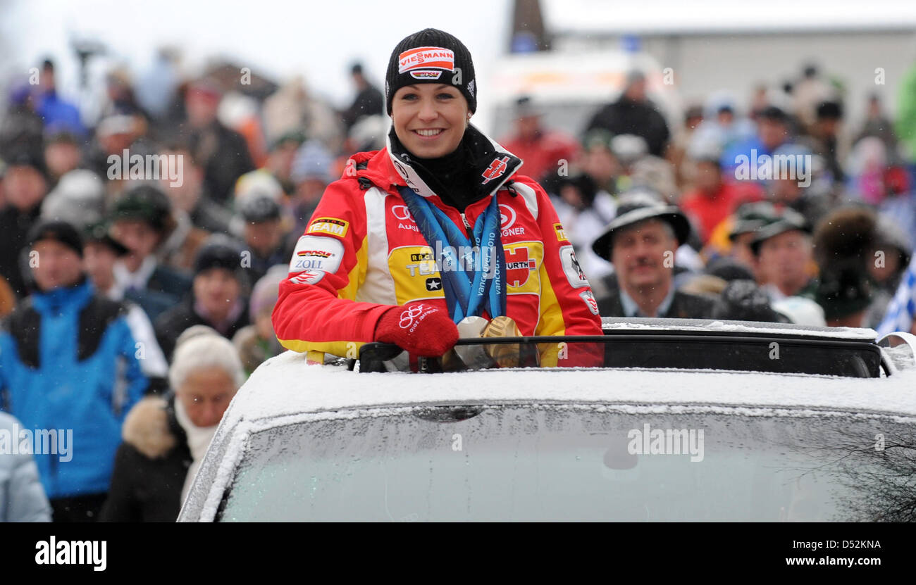 German biathlete Magdalena Neuner waves from a car and presents her medals during the reception in her home town Wallgau, Germany, 05 March 2010. Neuner won two gold medals and one silver medal at the Olympic Winter Games 2010 in Vancouver, Canada. A stage was specially built stage on the town square for the occasion. Photo: TOBIAS HASE Stock Photo