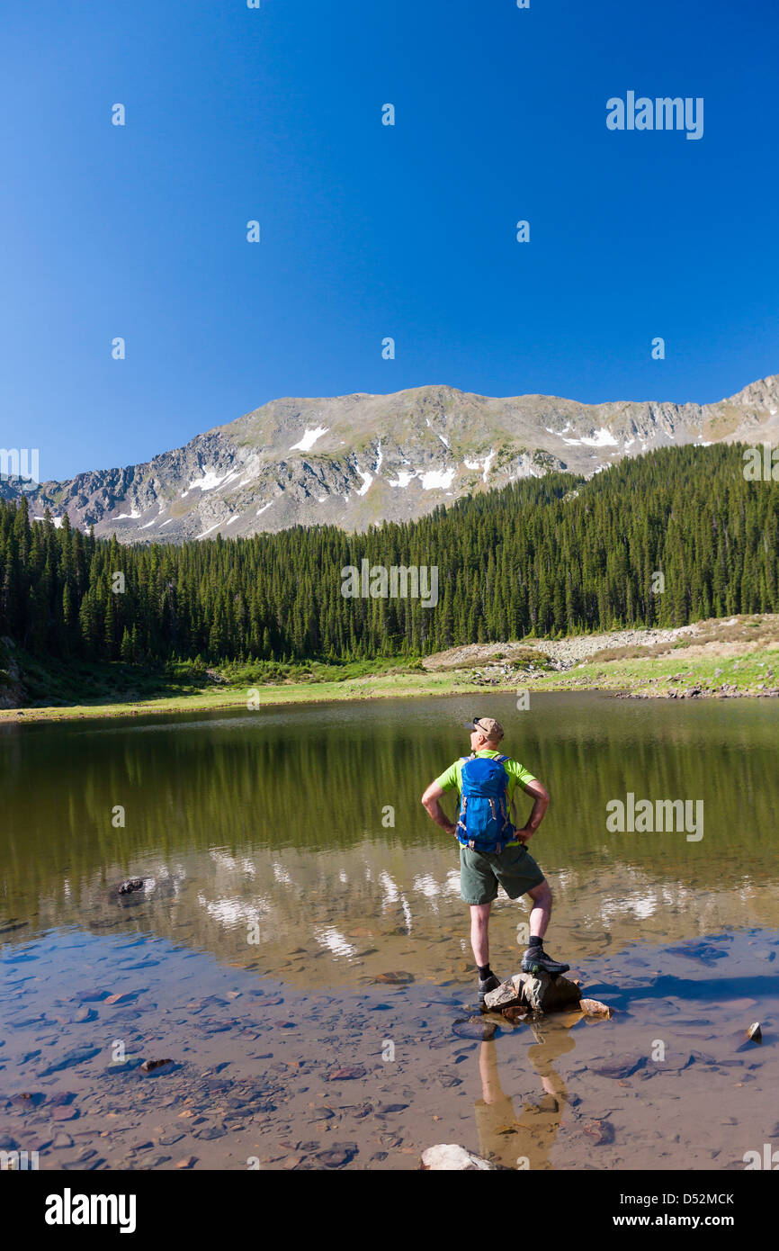Caucasian hiker standing on rocks in lake Stock Photo - Alamy