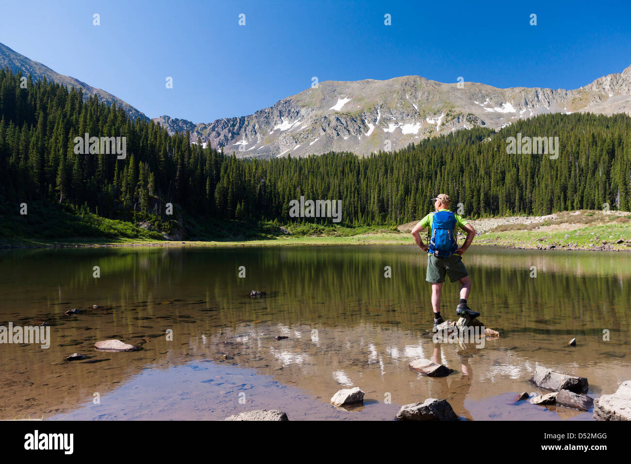 Caucasian hiker standing on rocks in lake Stock Photo - Alamy