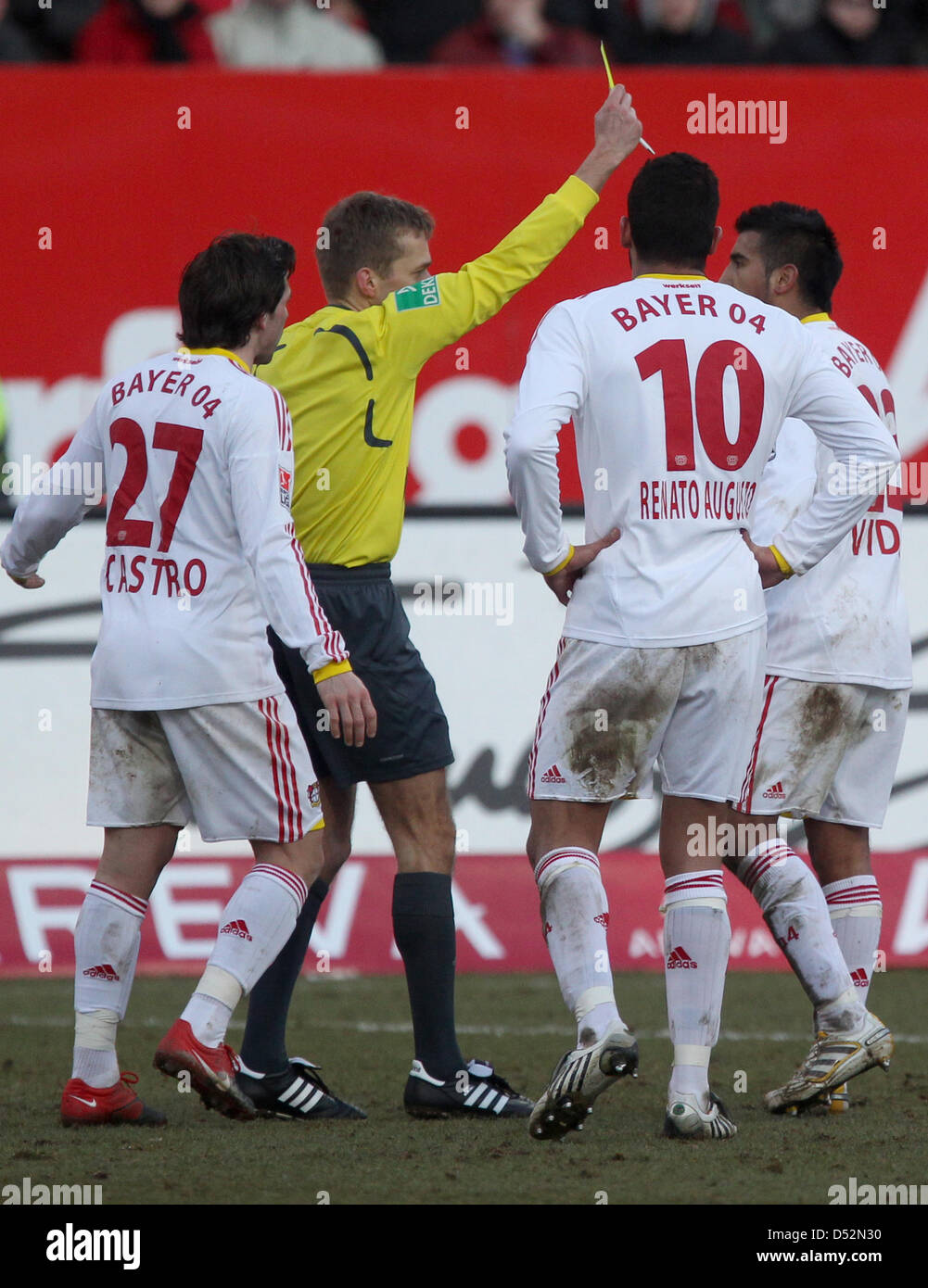 Referee Jochen Drees (2-L) shows Leverkusen's Arturo Vidal (R) the yellow card during German Bundesliga match Nuremberg vs Bayer Leverkusen at easyCredit-Stadium in Nuremberg, Germany, 07 March 2010. The match ended 3-2. Also depicted are Leverkusen's Gonzalo Castro (L) and Renato Augusto. Photo: DANIEL KARMANN (ATTENTION: EMBARGO CONDITIONS: The DFL permits the further utilisation Stock Photo