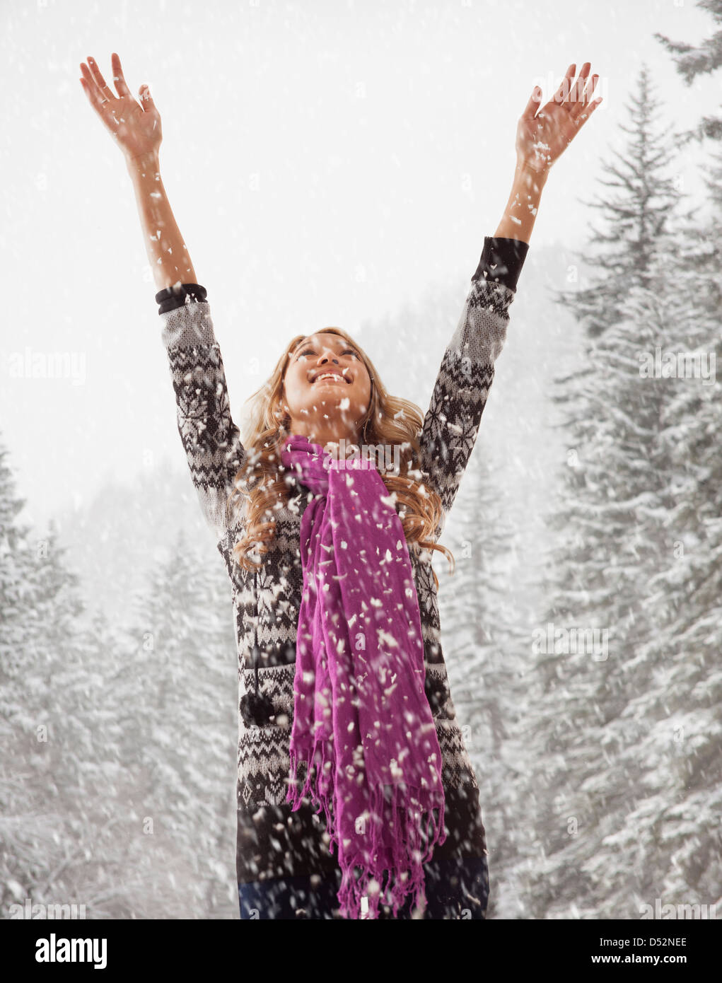 Mixed race woman playing in snow Stock Photo