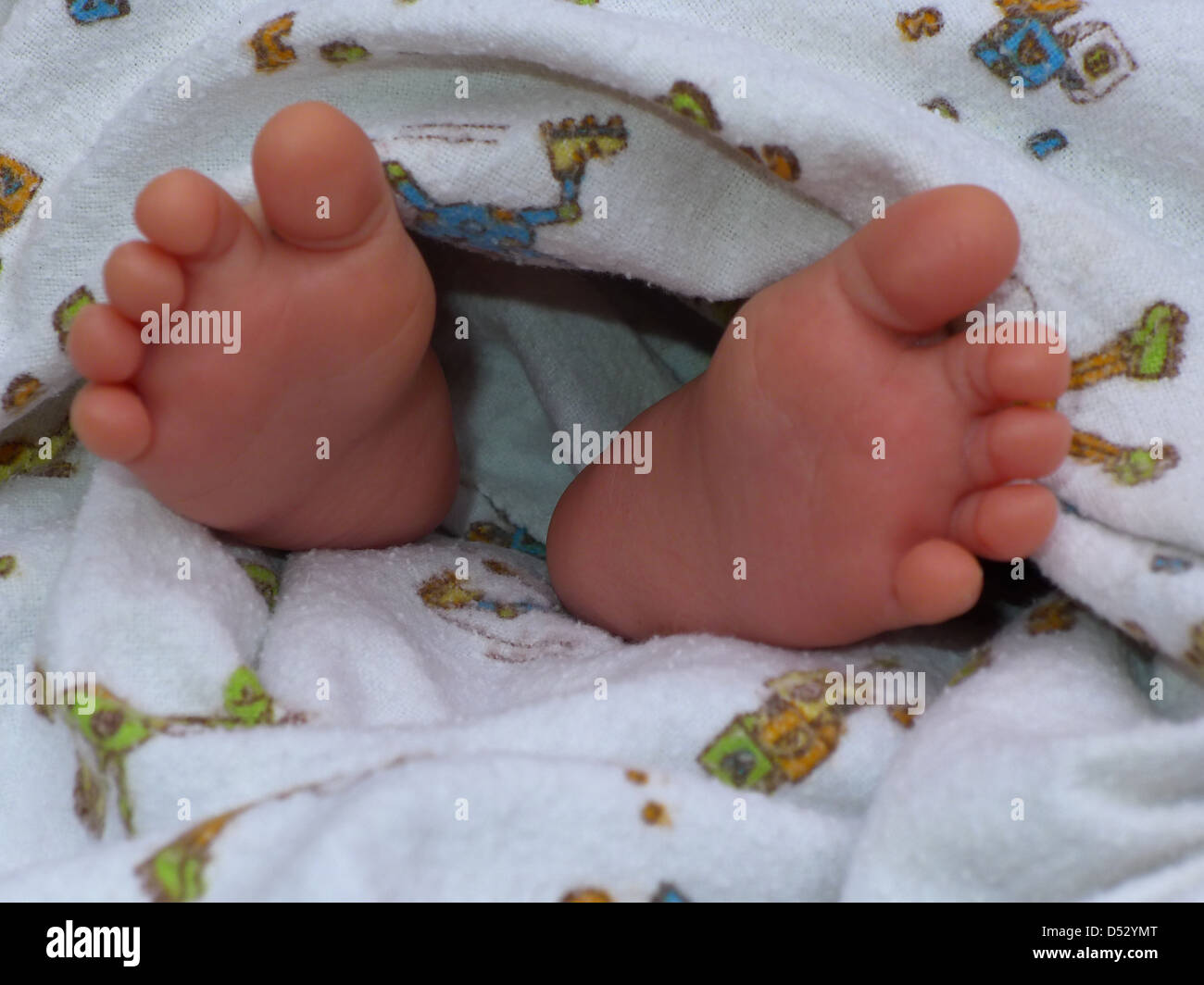 Cute baby feet sticking out of a blanket Stock Photo