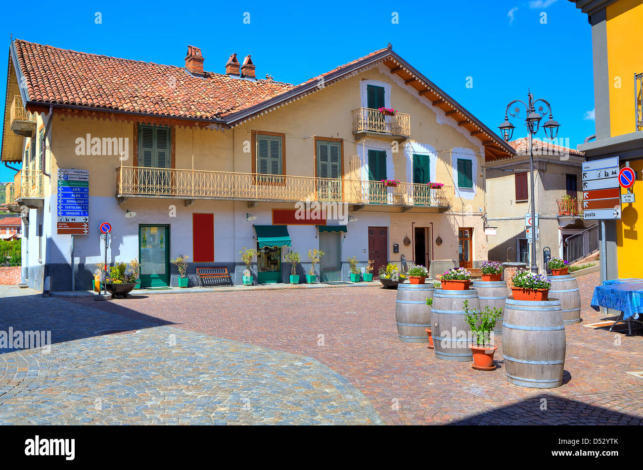 View of small cobblestone plaza at the center of typical italian town among colorful houses in Barolo, Italy. Stock Photo