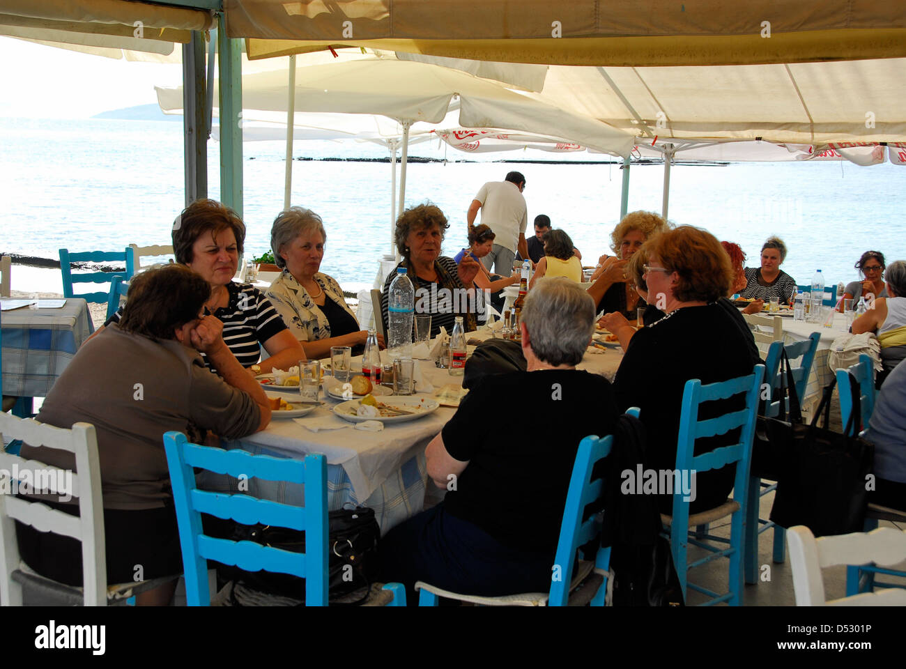 Women having lunch at a restaurant on the island of Aegina in the Saronic Gulf in Greece Stock Photo