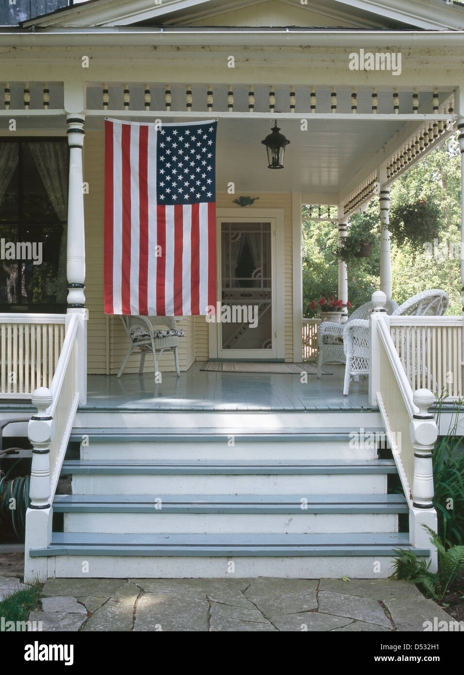 American flag hanging at front porch of house Stock Photo