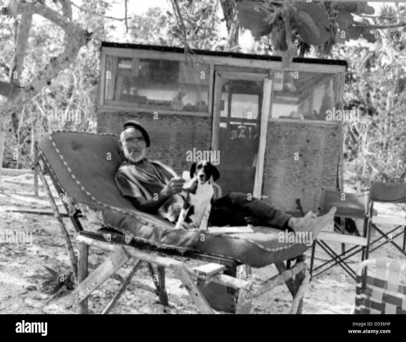 Old hermit Roy Ozmer poses with his dog on a self-made lounge chair: Gomez Point, Florida Stock Photo