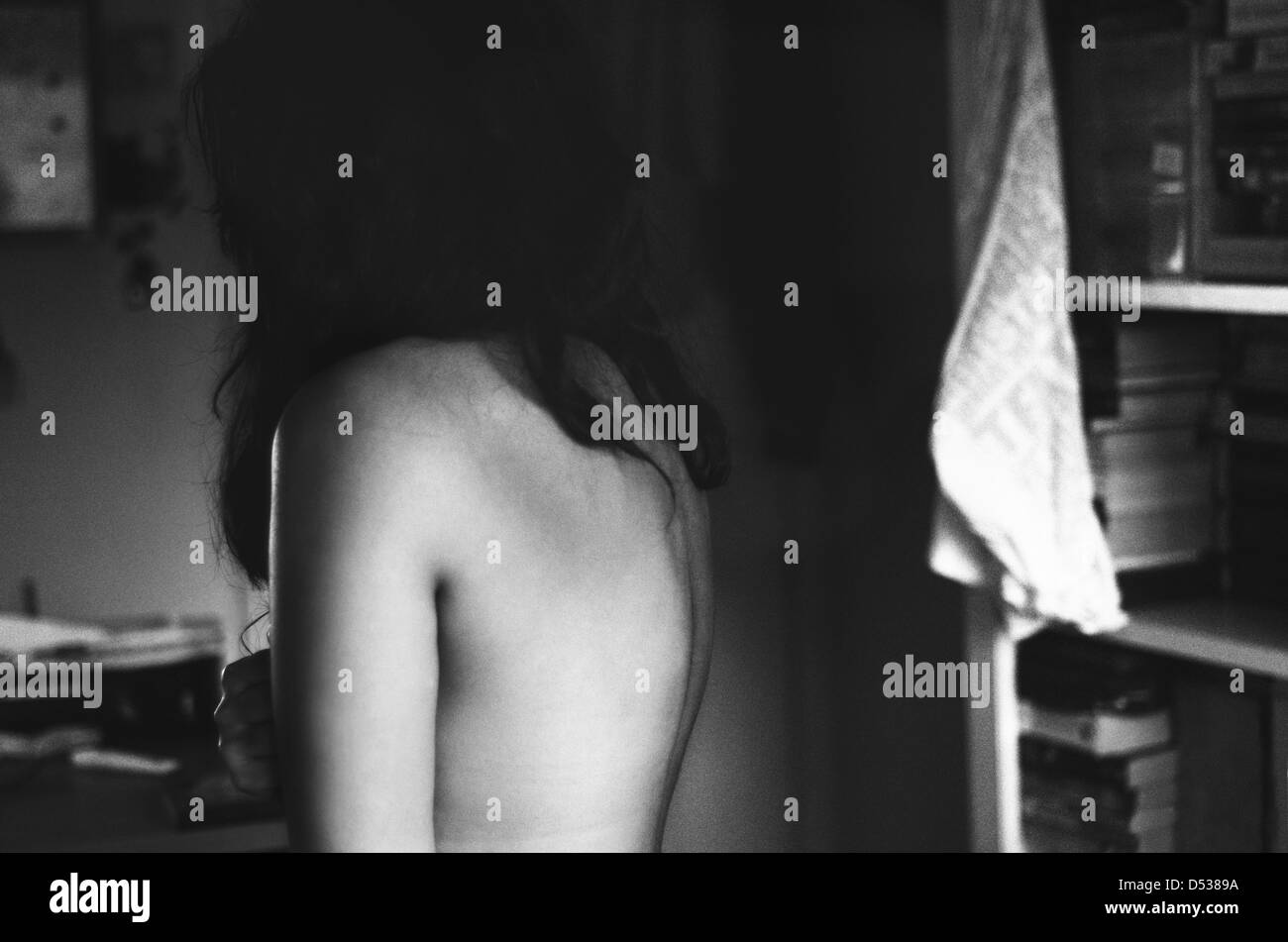 A cropped, monochrome photograph of a girl's nude back. Stock Photo