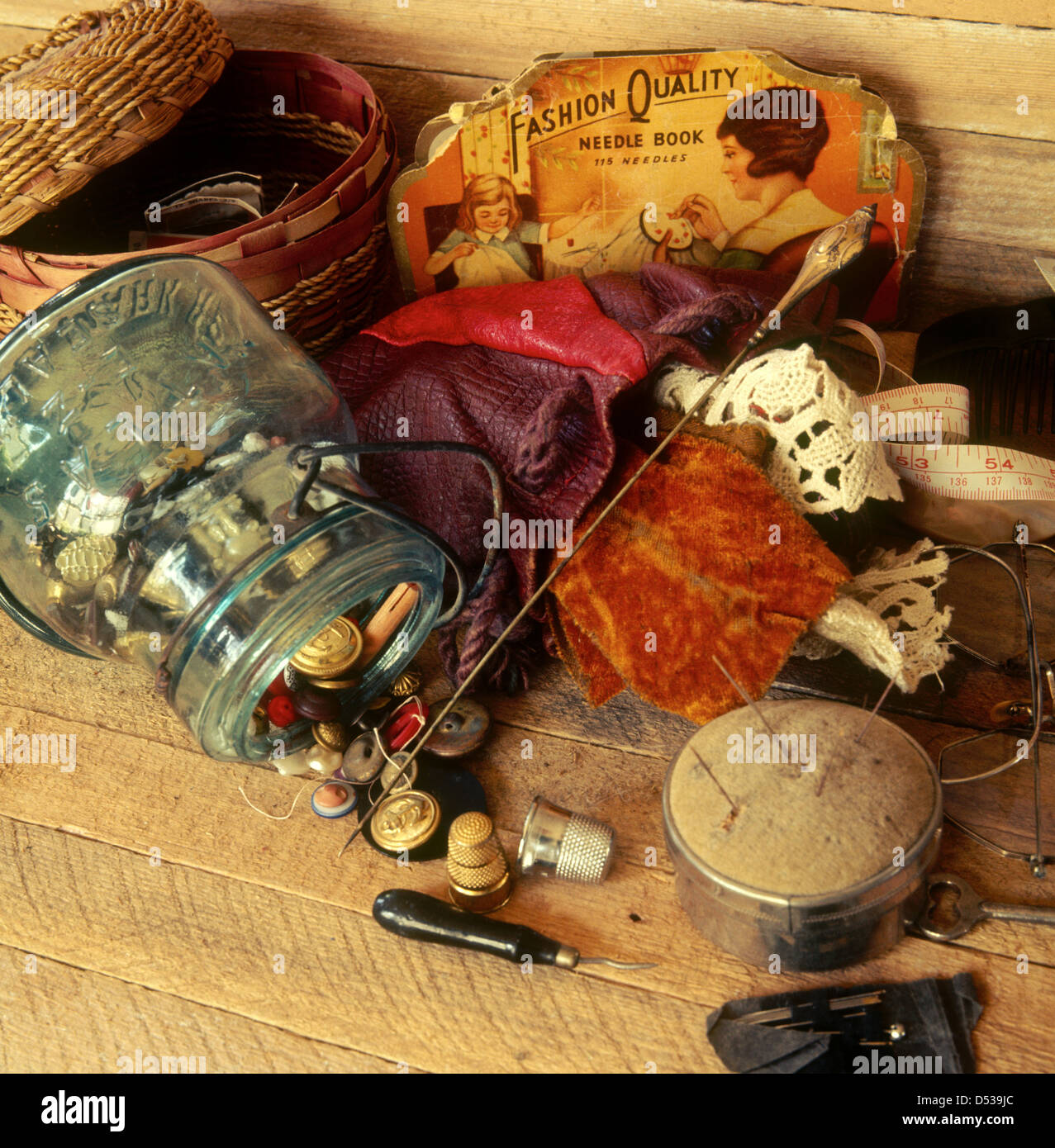 Reminiscing over old sewing supplies buttons, basket, thimbles, tape measure, hat pin, and glasses. Lincoln Nebraska NE USA Stock Photo