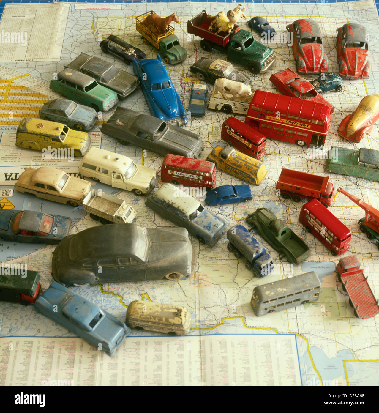 Antique collectable toy cars autos busses and trucks spread out over a Minnesota road map. Lincoln Nebraska NE USA Stock Photo