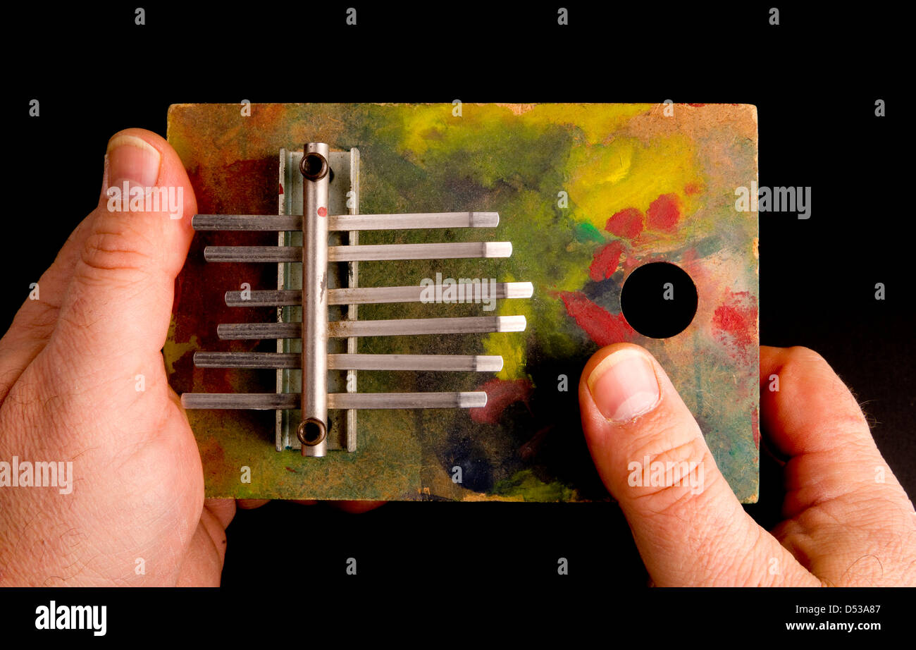 Hands Playing Tune on Musical Instrument of the Thumb Harp Stock Photo