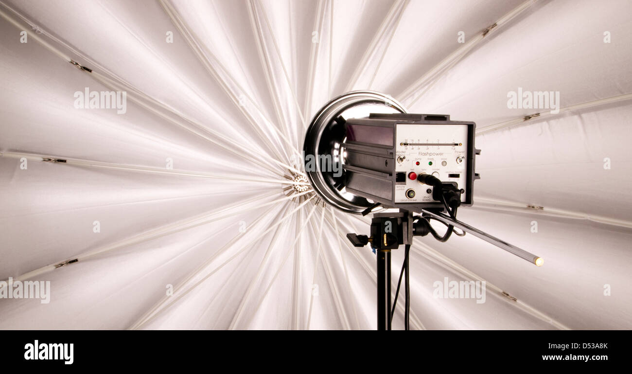 Hi Wattage Flash Head Lights up Large Studio Umbrella Stock Photo