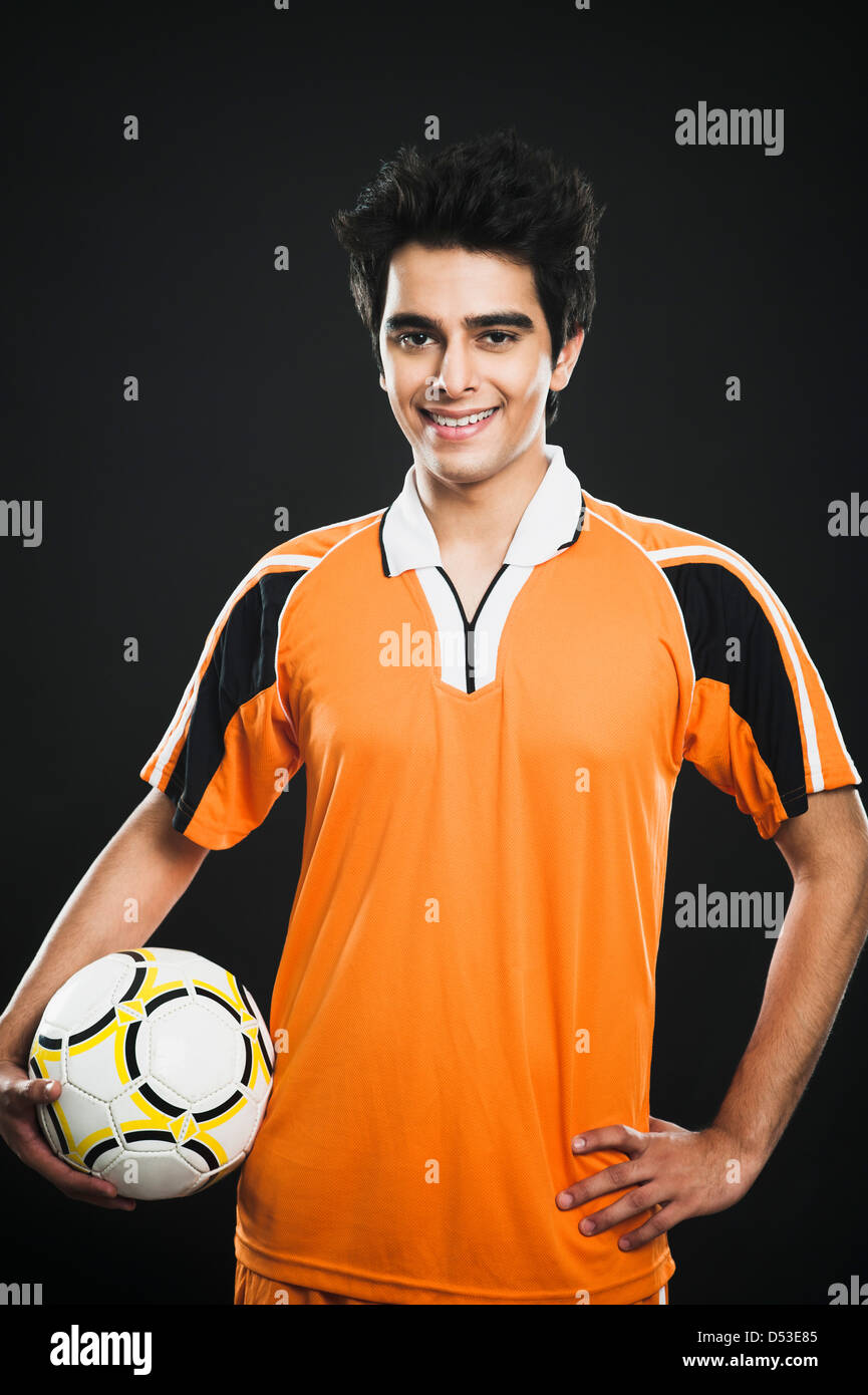 Portrait of a soccer player holding a soccer ball and smiling Stock ...