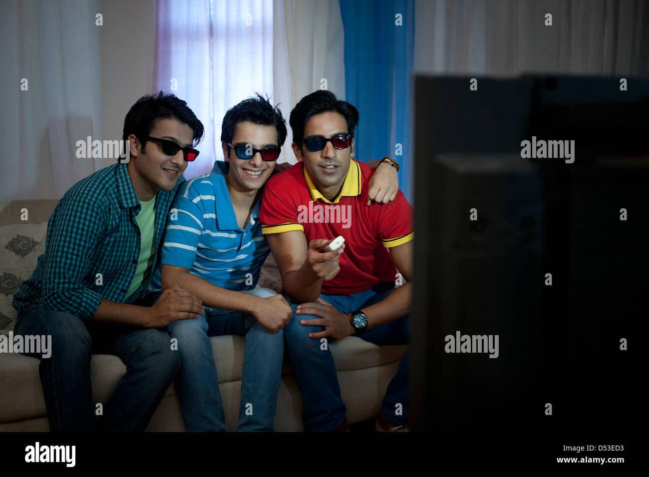 Friends watching television with 3D glasses at home Stock Photo Alamy