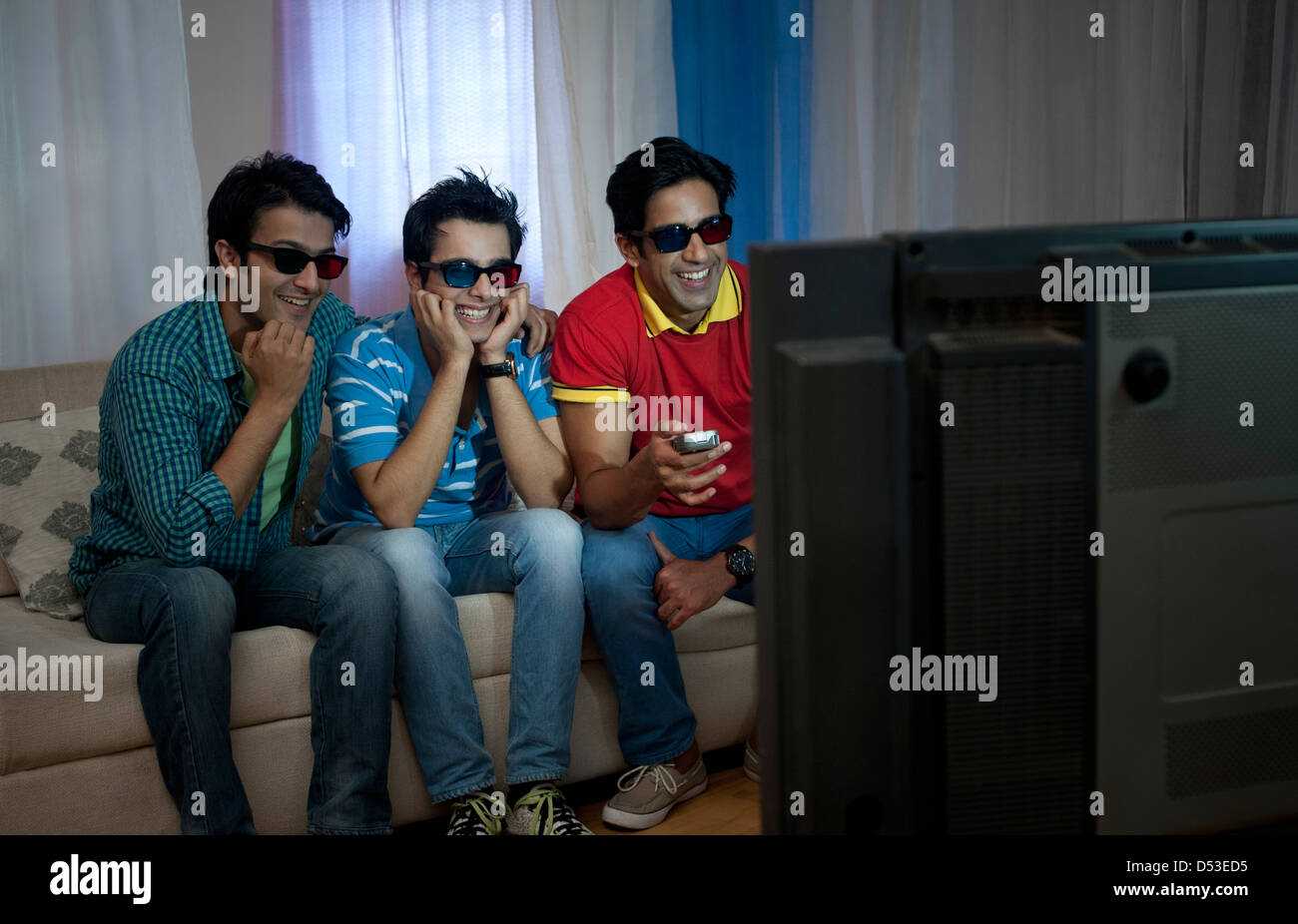 Friends watching television with 3D glasses at home Stock Photo Alamy