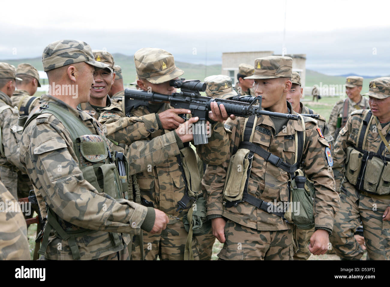 Mongolian armed forces soldiers examine a U.S. Marine Corps issued M-4 carbine as part of Khaan Quest 2009 at the Five Hills Training Area August 14, 2009 in Mongolia. Stock Photo