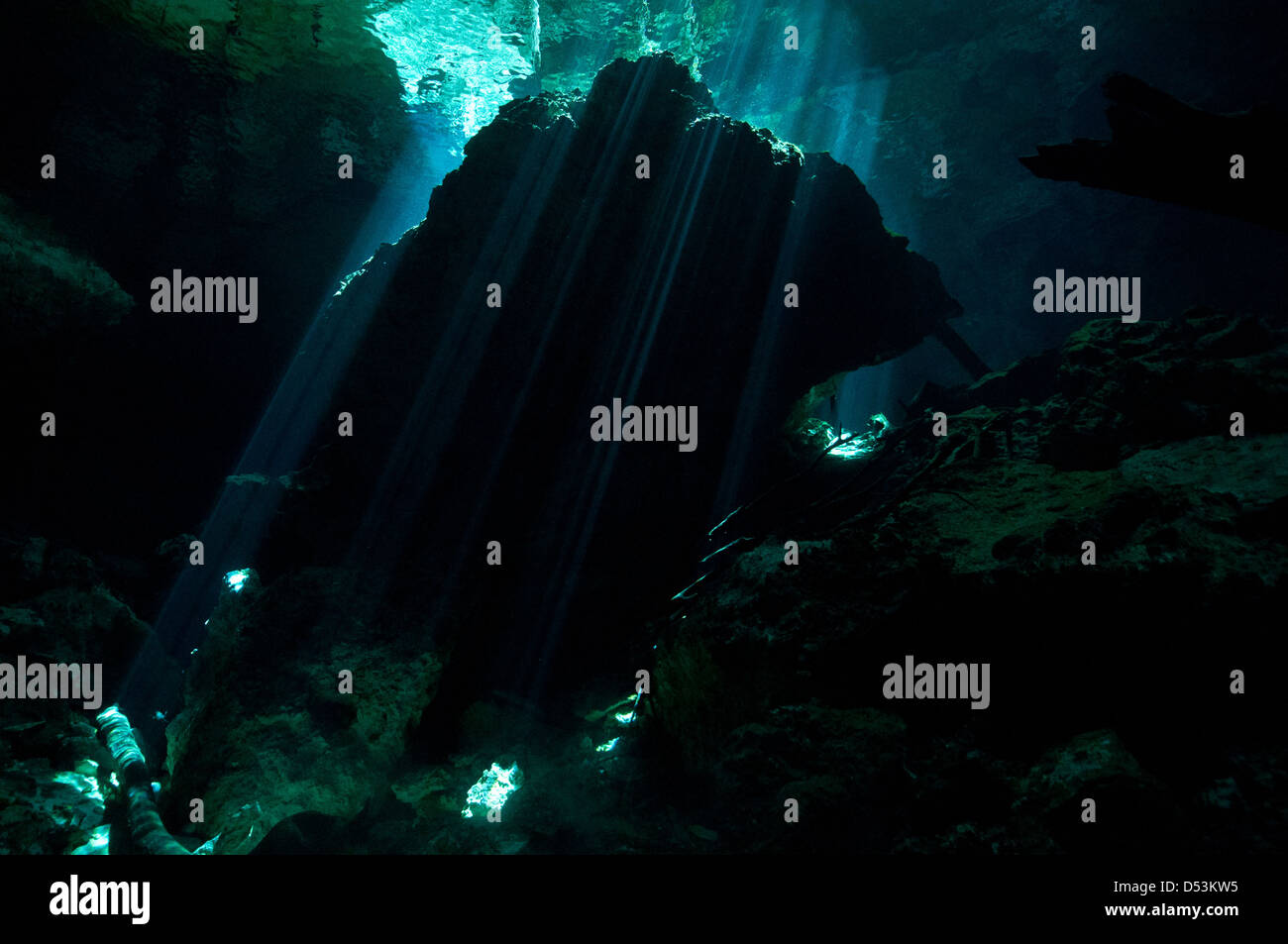 Cenote cave, rock formation underwater with ambient light and silhoettes Stock Photo