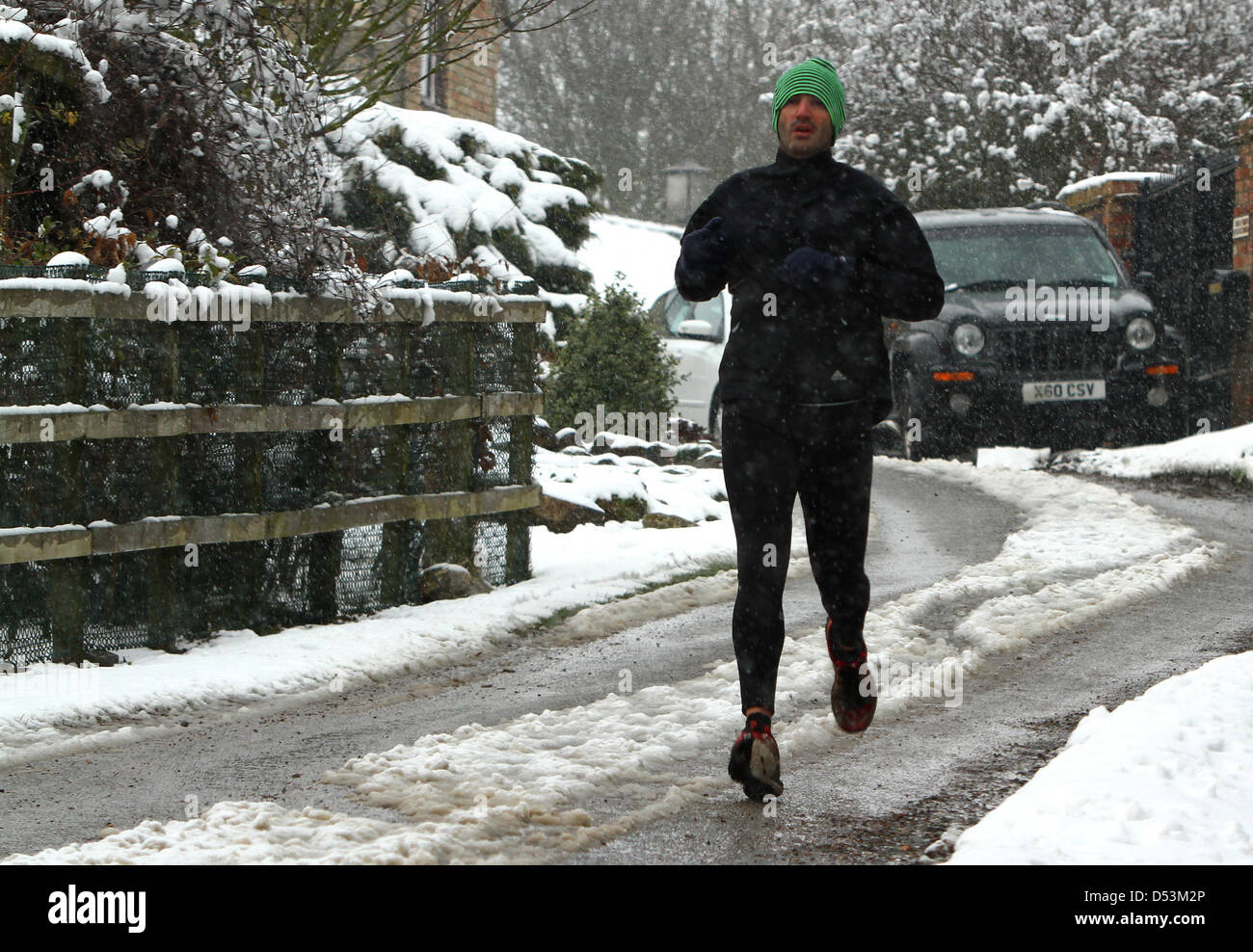Grafham water, Cambridgeshire, UK. 23rd March 2013. Spring in his step. A runner braves the unprecedented snow a week before Easter with a run near Grafham Water in Cambridgshire. Credit:  Colin Bennett / Alamy Live News Stock Photo