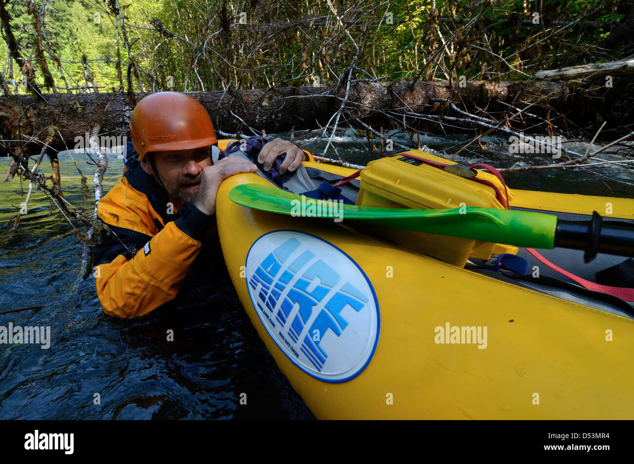 Swimming an inflatable kayaks under a downded tree on Oregon's South
